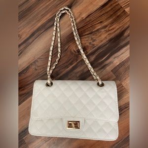 White quilted purse with red liner and gold chain strap